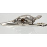 A silver plated wall mounting paper clip in the form of a ducks had set with yellow glass eyes.