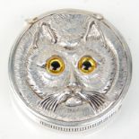 A stamped 800 silver vesta case of round form having raised decoration in the form of a cat set with