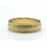 A 9ct gold band ring with reeded circumferential  design. Stamped 375. Total weight 3.3g / Size U.5.