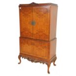 An early 20th Century Queen Anne style walnut drinks / cocktail cabinet of two tiered form, the