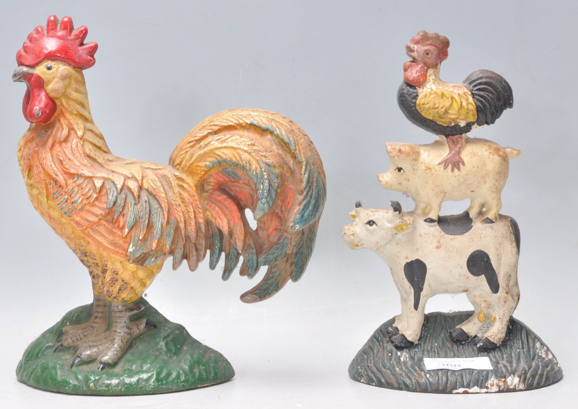 A 20th century cast iron doorstop in the form of a cockerel together with another having cow, pig,