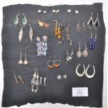A collection of ladies earrings most being silver to include a pair of think hoop earrings, drop