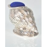A stamped 925 silver pincushion in the form of a conch shell, having a blue velvet cushion to the