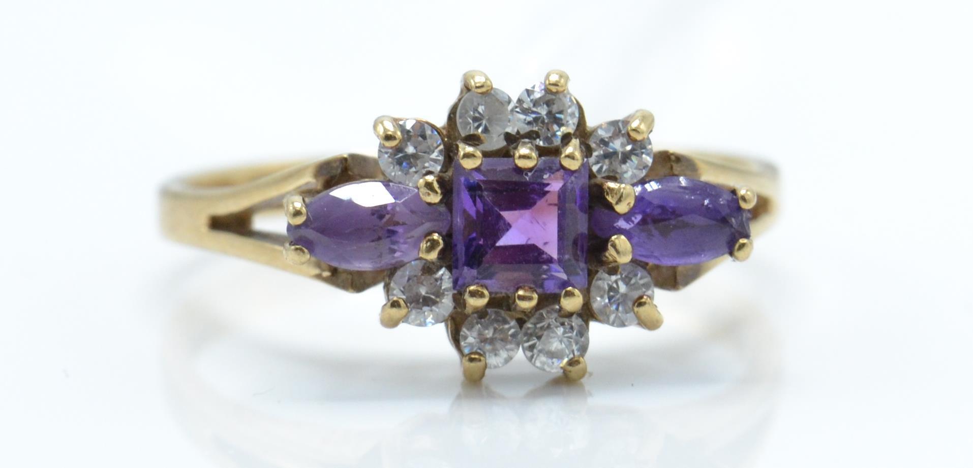 A hallmarked 9ct gold amethyst and white stone cluster ring. The ring set with 3 graduating