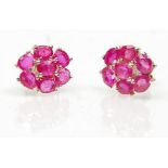 A pair of ladies stud earrings set with a cluster of oval cut rubies. Weight 2.7g. Measures 7mm.