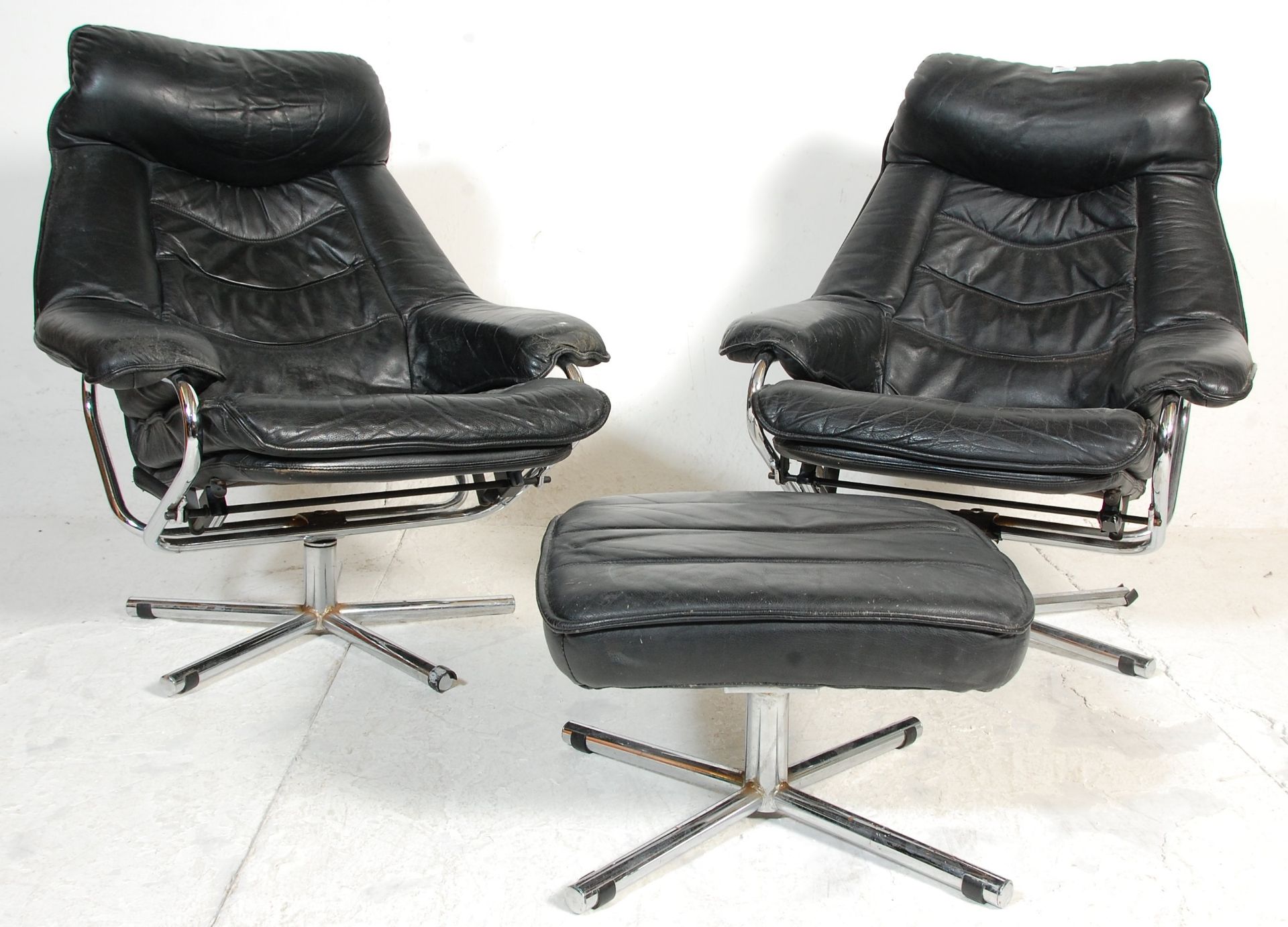 A pair of vintage retro 1970's Swedish black leather arm / lounge chairs, each raised on chrome