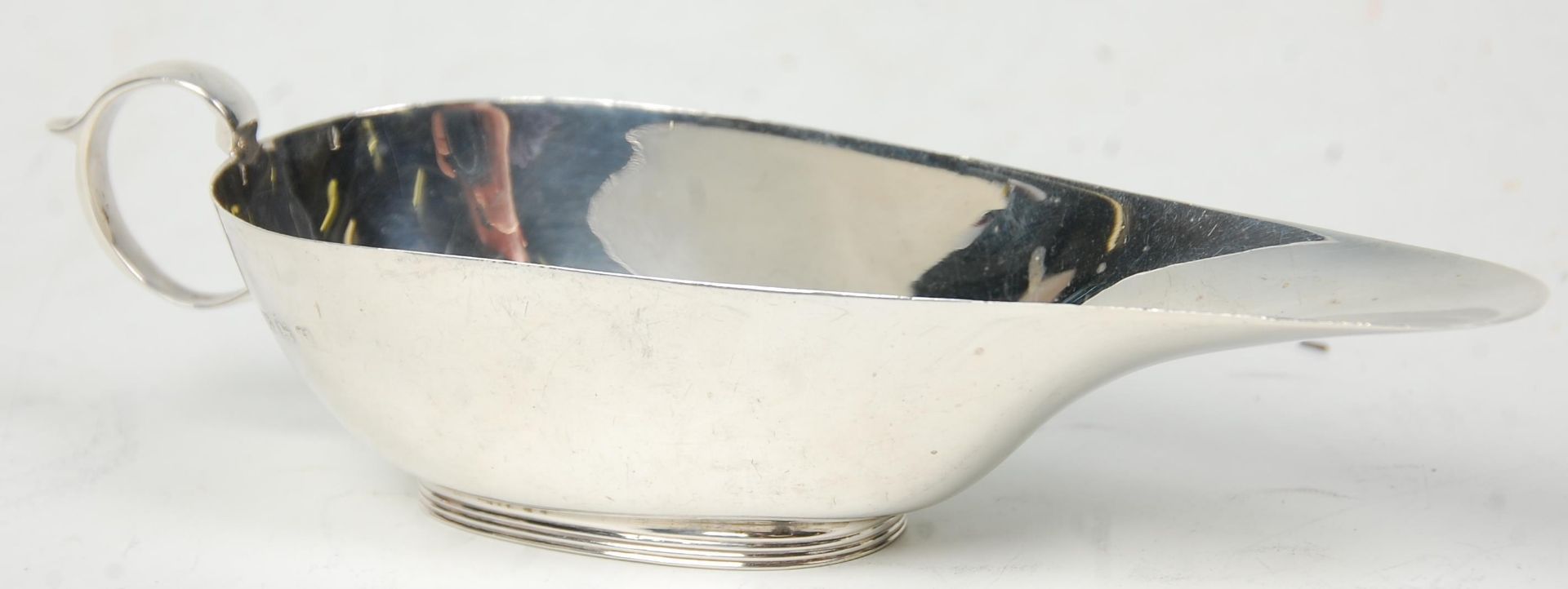 An early 20th Century Art Deco silver hallmarked sauce boat of stylish form. Hallmarked for