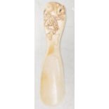 An early 20th Century Japanese ivory shoe horn having a carved handle in the form of a rat on a