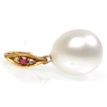 A stunning large cultured pearl pendant on a gold bail set with a single ruby flanked by diamonds.