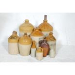 A collection of early 20th Century stoneware advertising flagons of various shapes and sizes in