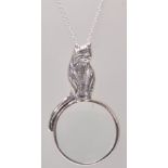 A stamped 925 silver pendant necklace having a magnifying glass pendant having a cat handle with a