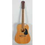 A 20th Century Freshman twelve string guitar having a black scratch board with inlaid markers to the