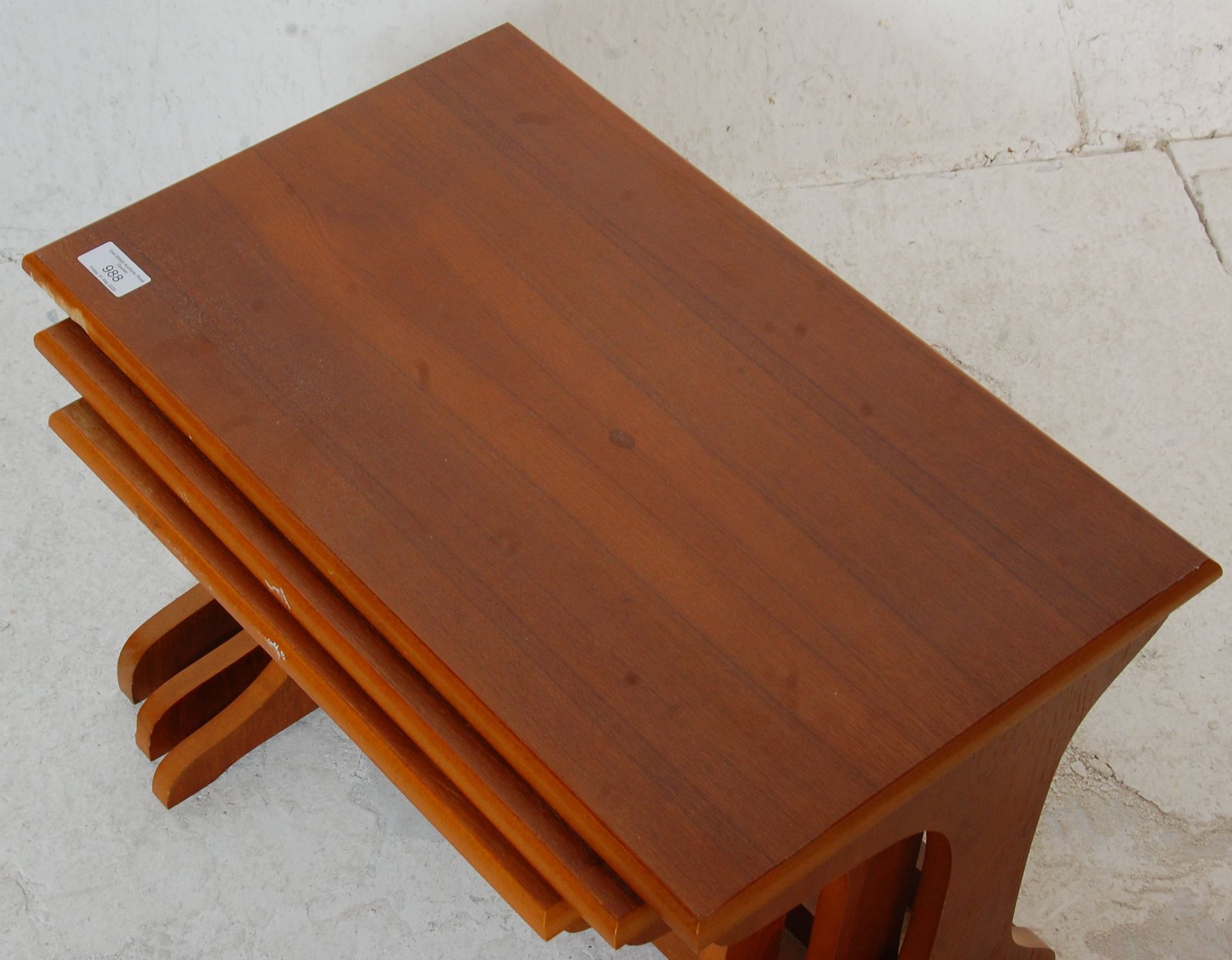 A 1970's vintage retro teak wood nest of tables having shaped legs united by stretchers with - Bild 2 aus 4