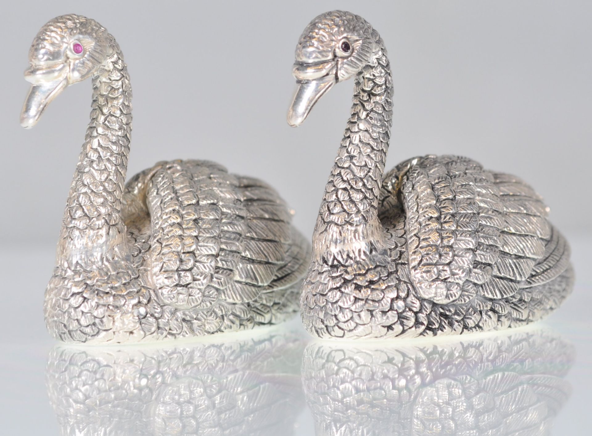 A pair of stamped 925 silver condiments in the form of swans having raised details and set with