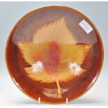 A vintage retro Poole pottery Aegean series plate of round form having  brown glaze with a large