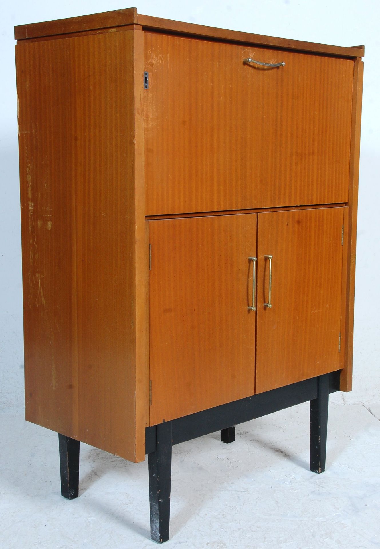 A mid century retro teak wood Danish inspired bureau desk. Raised on tapering legs with a double