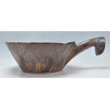 A antique African carved hardwood tribal bowl of conical form having a large carved handle to one