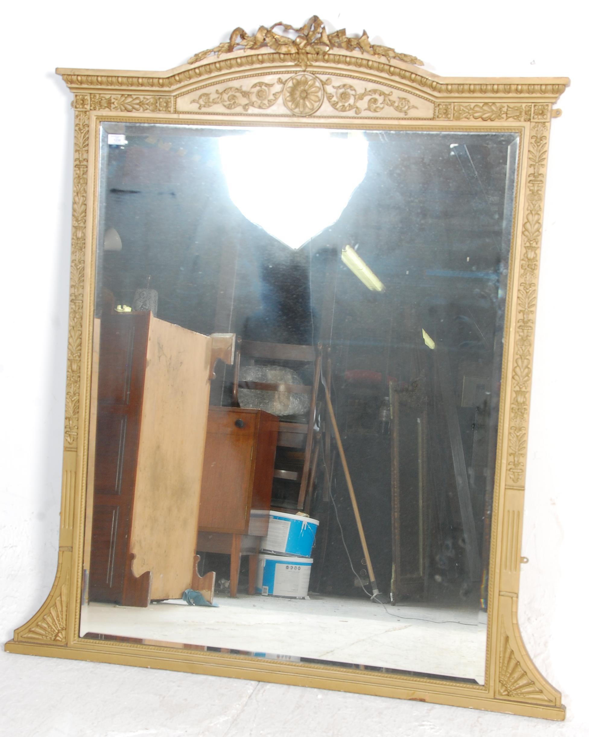 An antique early 19th Century regency wall mirror having a gilt frame with moulded gilt decoration