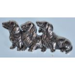 A stamped sterling silver brooch in the form of three Dachshunds set with ruby eyes. Weight 10g.