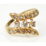 A hallmarked 18ct gold wrap around design dress ring set with three central diamonds, and two rows