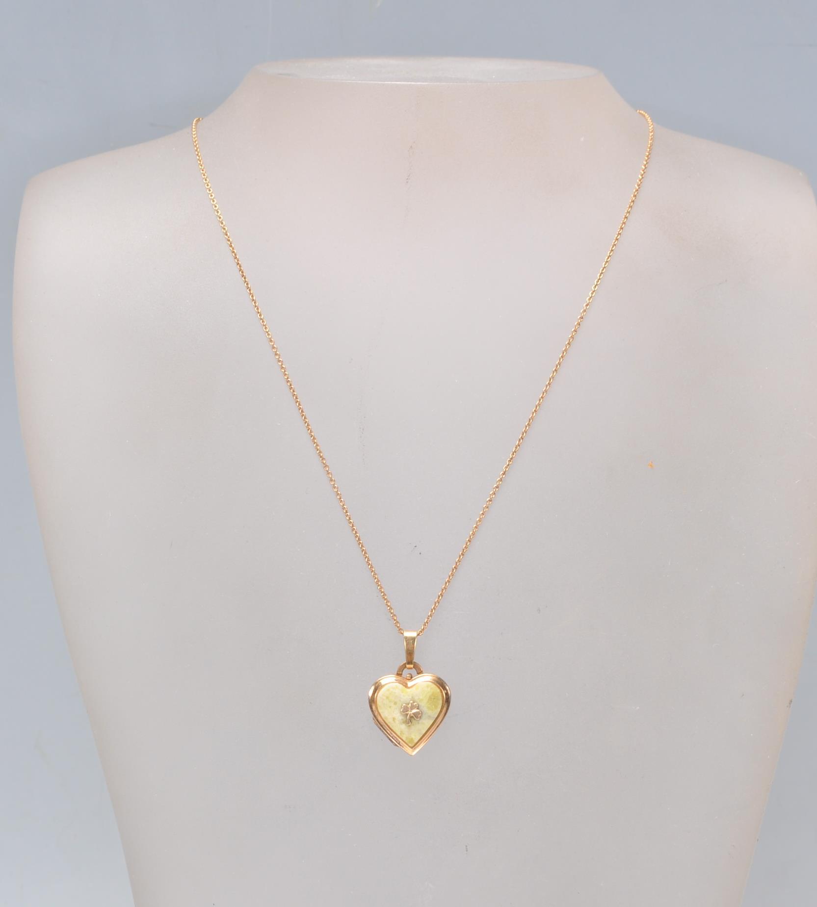 A stamped 14ct gold heart shaped pendant set with a green stone panel with a three leaf clover - Image 2 of 6