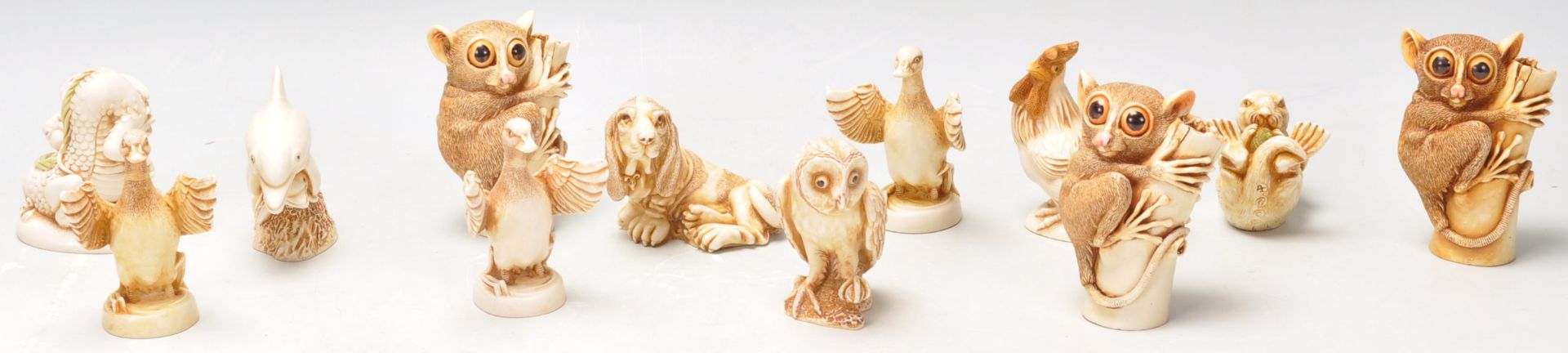 A group of twelve Harmony Kingdom resin animal figurines to include bush babies, owl, dolphin, duck,