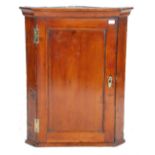 A 19th Century Georgian  / George III country pine hanging corner cabinet having a panelled door