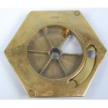An early 20th Century patent brass countertop till of hexagonal form having a round glass panel with
