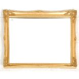 A contemporary antique style gilt wall mirror with shaped cushion frame surrounding bevelled edge