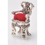 A stamped sterling silver pincushion in the form of a chair having red velvet cushion. Weight 17g.