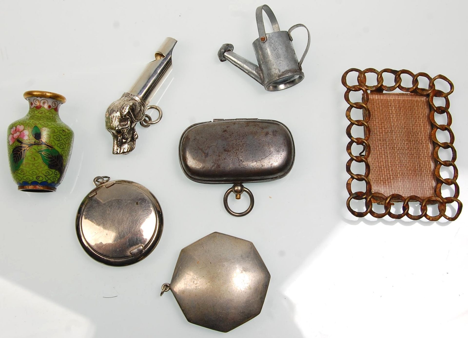 A mixed group of vintage curious to include a miniature iron work frame, a silver plate whistle in