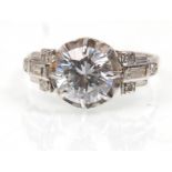 A platinum ladies dress ring set with a large central CZs stone with diamond accent stones to the