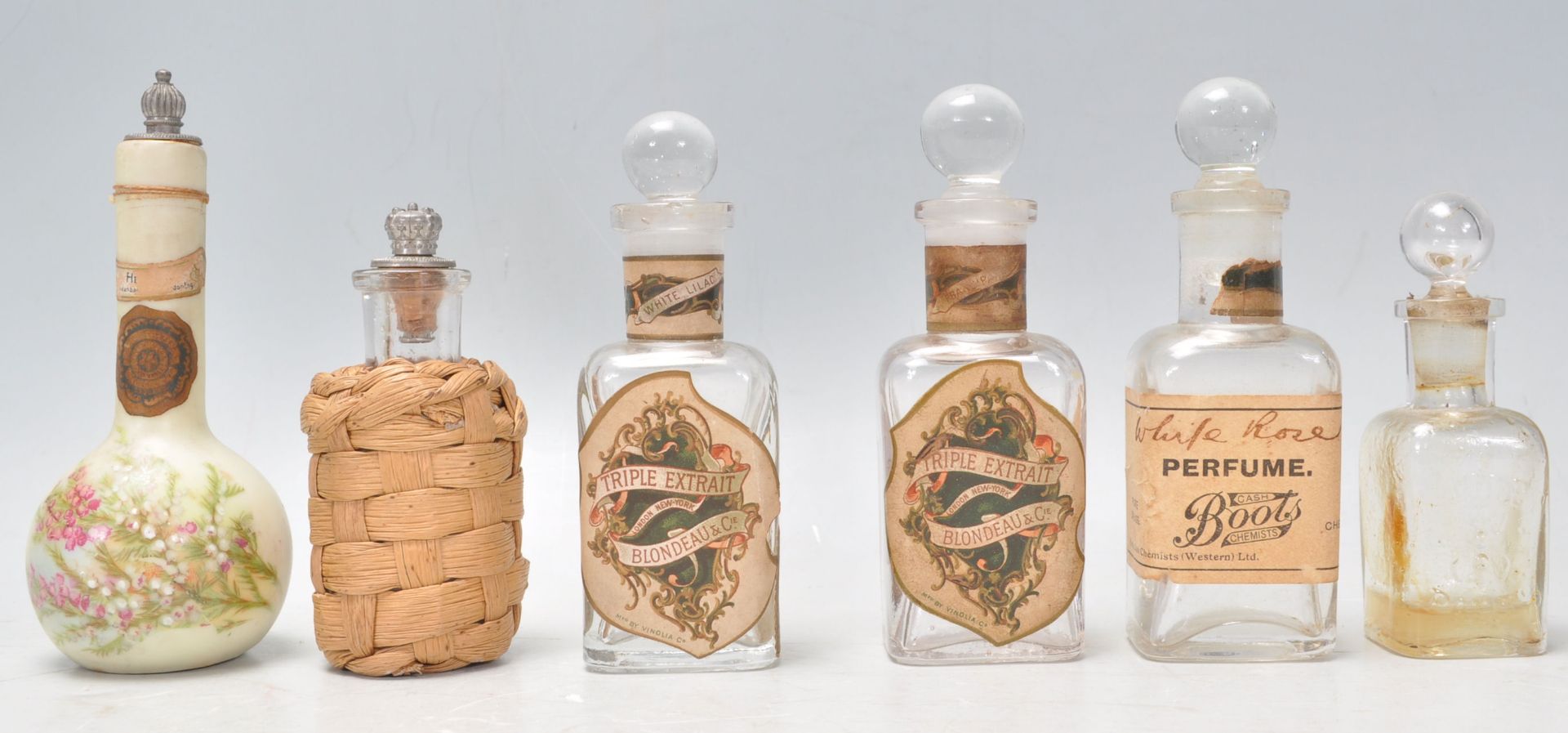 A collection of early 20th Century antique advertising perfume scent bottles, most of square form