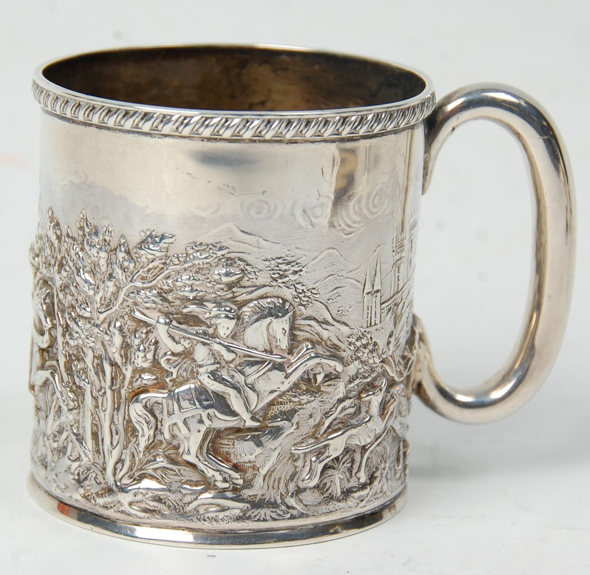 A late 19th Century Victorian silver hallmarked mug having repousse decoration depicting a
