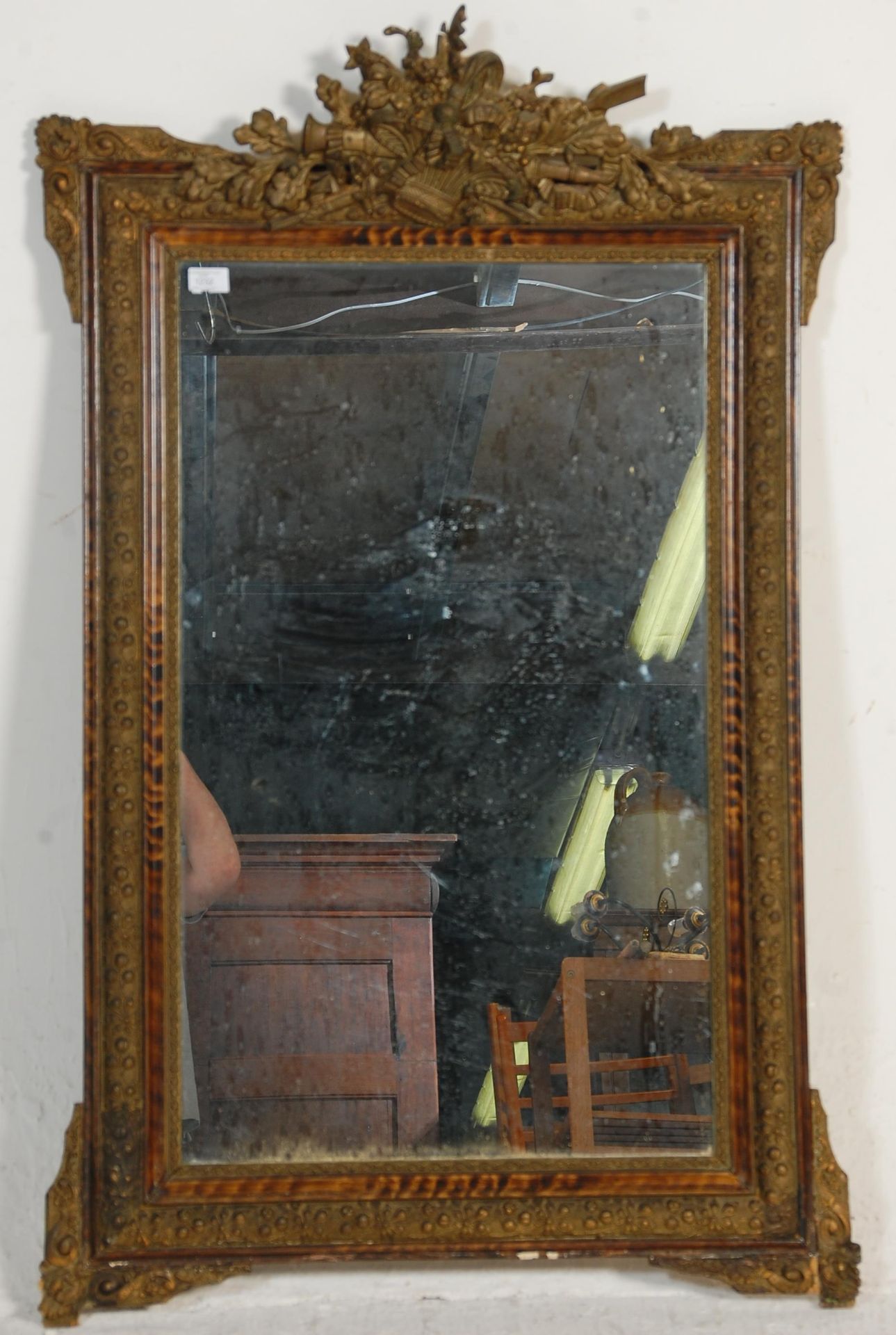 A 19th Century French wall mirror having a moulded gilt frame having raised floral and foliate