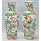 A pair of 19th Century Chinese famille verte porcelain baluster vases being hand enamelled over a