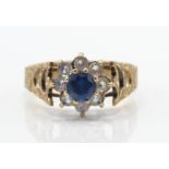 A 9ct gold sapphire and diamond cluster ring. The central sapphire within a halo of diamonds.