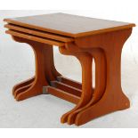 A 1970's vintage retro teak wood nest of tables having shaped legs united by stretchers with