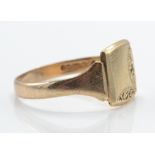 A 9ct gold signet ring. The plain cartouche  with chased edges to tapering shoulders and plain