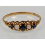 An English hallmarked 9ct yellow gold ladies ring set with sapphires and opal cabochons on a