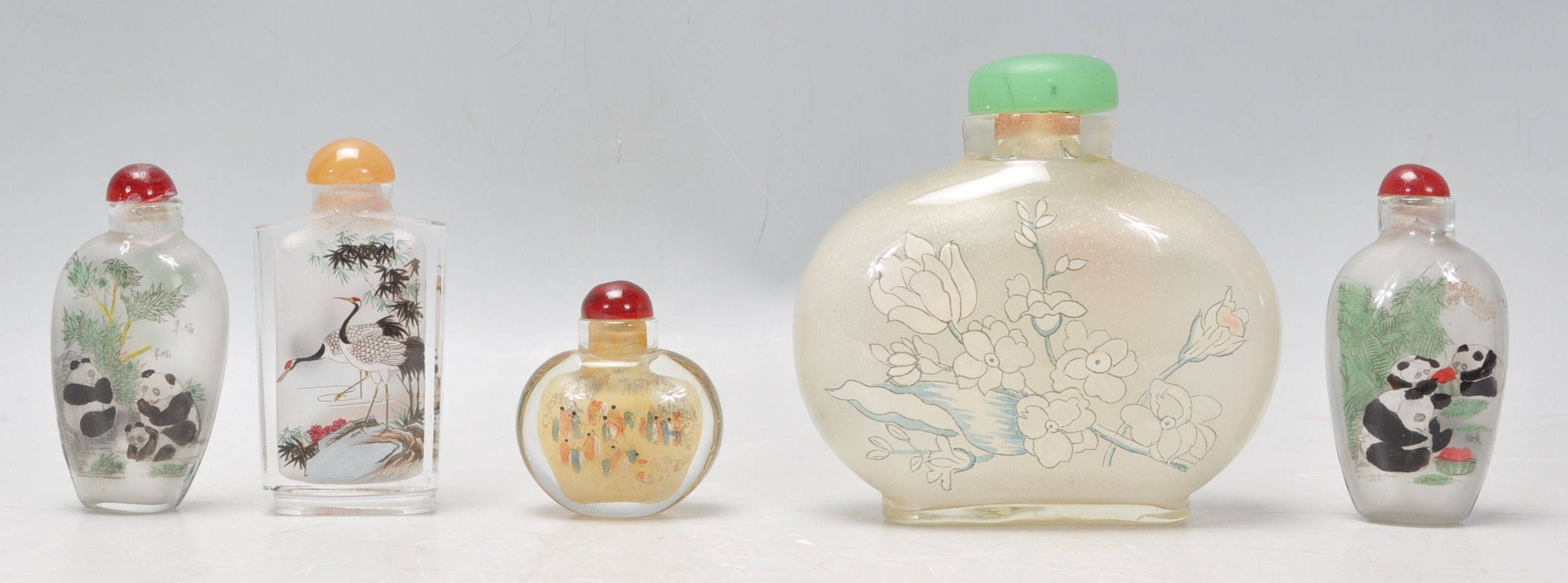 A group of five Oriental Chinese glass painted perfume scent bottles of varying form and decoration.