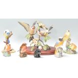 A collection of ceramic bird figurines to include a Royal Worcester Redstart, a Beswick Robin, a