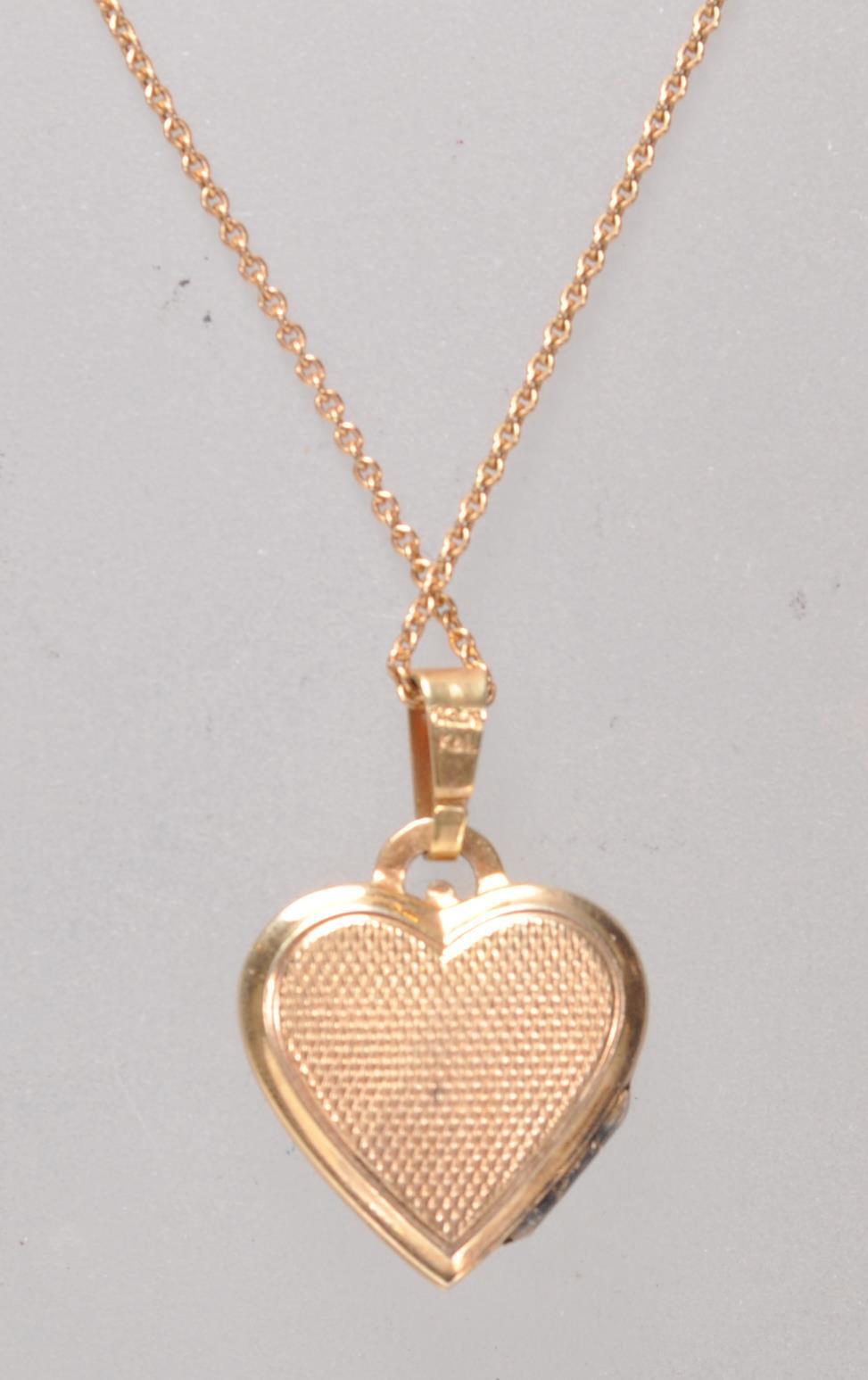 A stamped 14ct gold heart shaped pendant set with a green stone panel with a three leaf clover - Image 3 of 6
