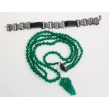 A lovely early 20th Century Art Deco green glass bead necklace with a decorative carved pendant with