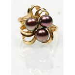 A stamped 14ct gold ring having a twist design set with three pearls and a central diamond. Weight