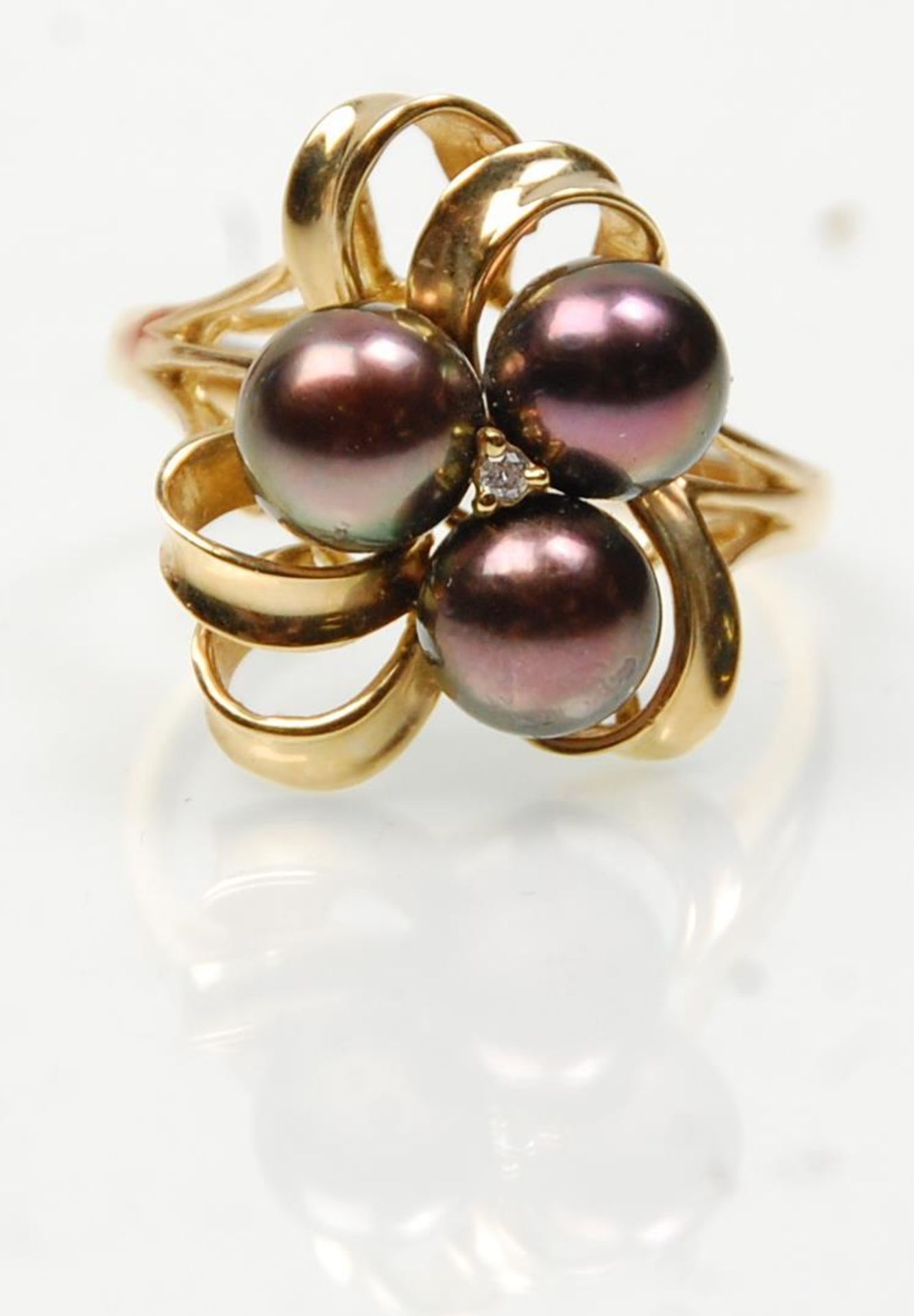 A stamped 14ct gold ring having a twist design set with three pearls and a central diamond. Weight