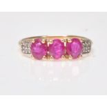 A 9ct gold ruby 3 stone ring. Stamped 375 with additional 10k mark. The 3 rubies within prong