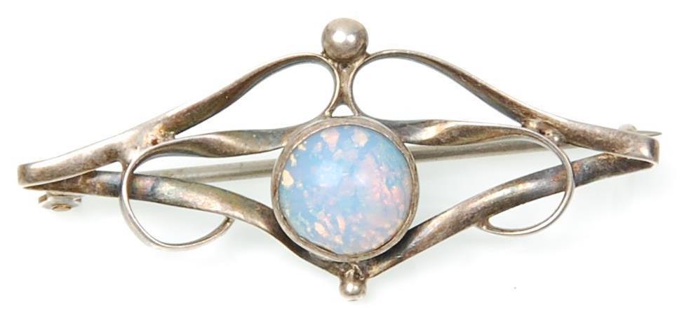 An early 20th Century Art Nouveau silver brooch set with a central opal panel within an openwork