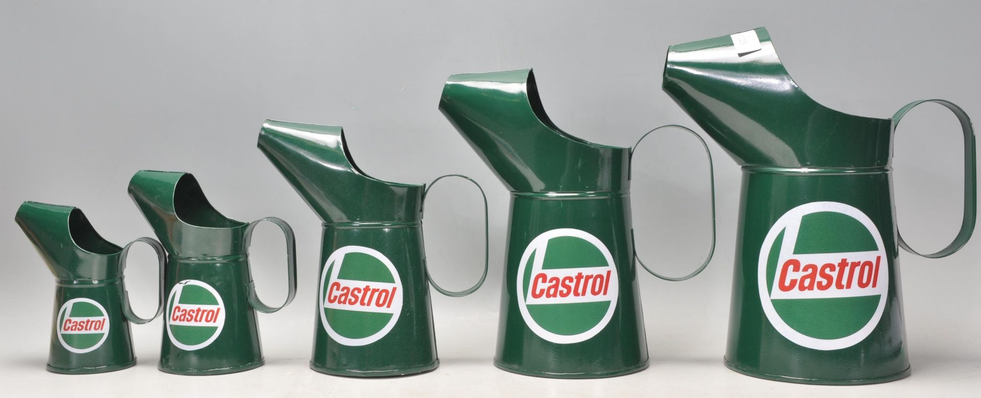 A good group of five graduating Castrol advertising oil measure jugs finished in green.