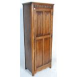 A 1930's oak Art Deco wardrobe having a singe four panelled door with carved graphic decoration to